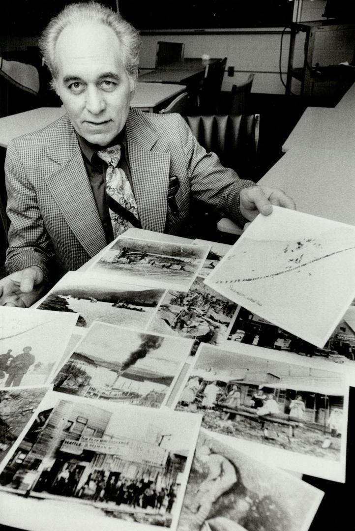 Old Pictures of the Klondike gold fields that he inserted in his movie are checked over by photographer Lyle Bebensee. The Humber College instructor spent three years at more than $20,000 creating a 30-minute film of the 1898 gold rush trail