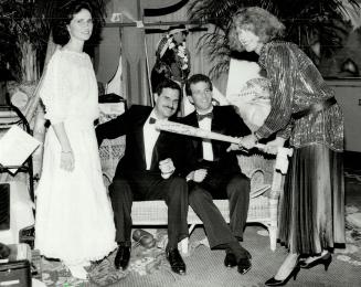 Admiring the baseball bat signed by the Blue Jays and auctioned for $425 are, left to right, lawyers Arlene and Mitchell Wolfe and Michael Bregman of MMMuffins, with his wife Barbara at bat.