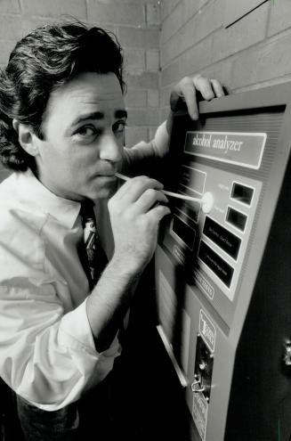 Take a deep breath: Gordon Brown tests one of his breathalyzer machines at Madison's in Toronto.