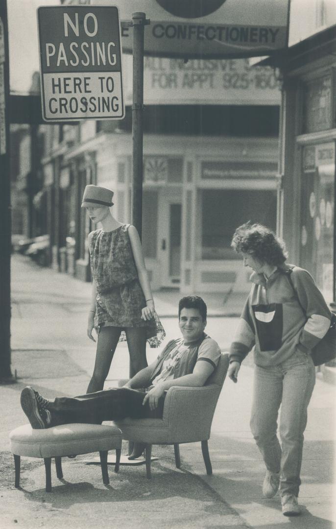 Laid back on Queen St. Anthony Caria relaxes yesterday outside his store called Locomotion on Queen St. E. The store, specializing in '40s and '50s memorabilia and collectibles, offers for sale Judy the mannequin, the chair and ottoman.