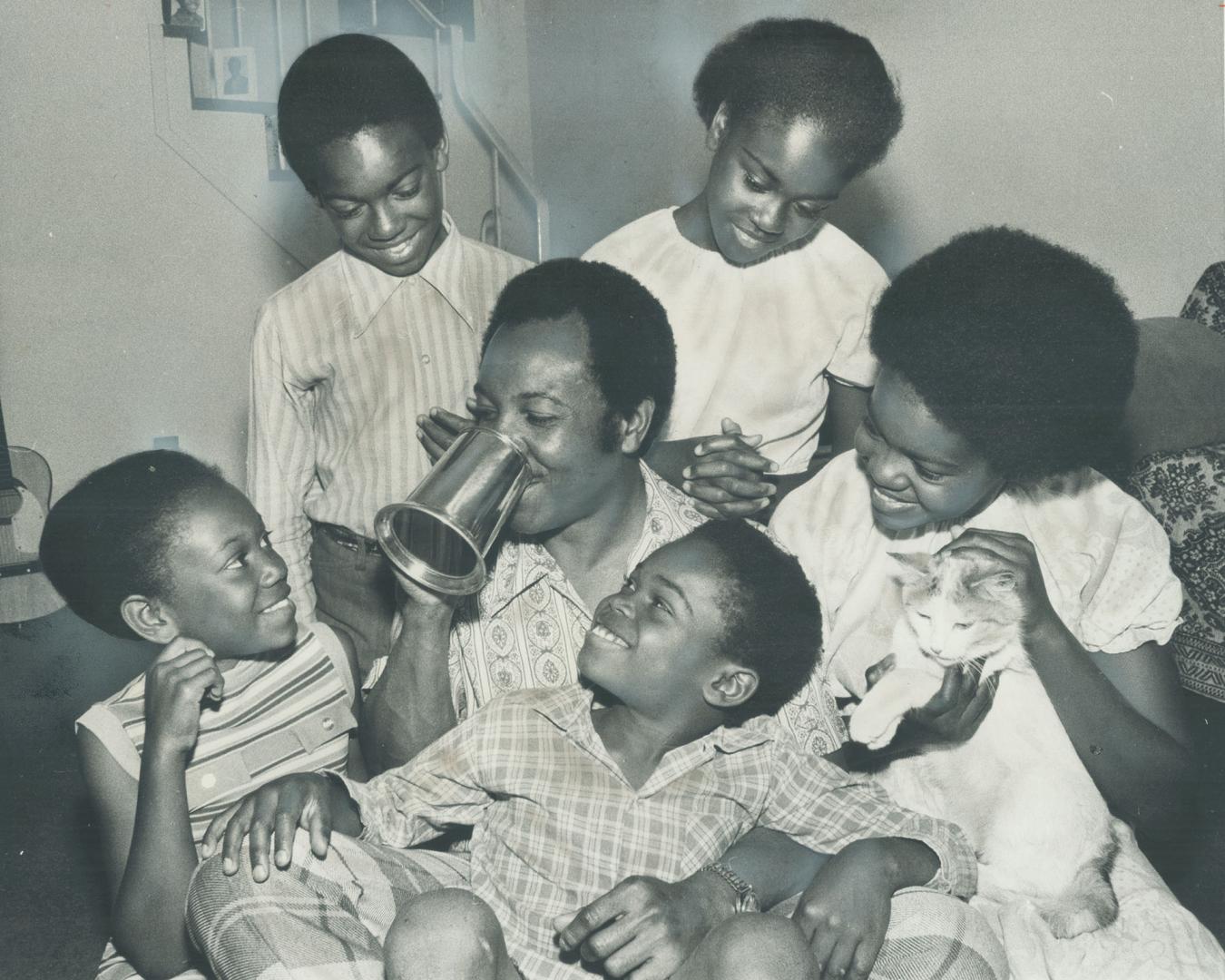 Brampton Solo Parents Association named its first Father of the Year Saturday - Neville Case, an engineering writer who's divorced and raising his five children. He tries out the trophy tankard given him, surrounded by the children-Joan, 13, Mike, 12, Yvonne, Eileen, 10, and Philip, 7-and Diamond the cat. So far as t Brampton club knows, it's the first Solo Parents award in Cana [Incomplete]