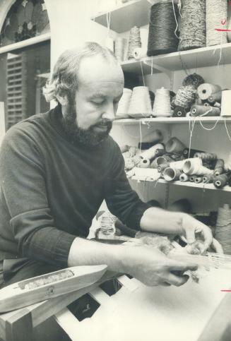 Weaver Robert Cawood is at work at his loom in his shop The Village Weaver, at Church and Mon eith Sts. The craftsman, who learned his skills in his native Yorkshire, England, has been teaching Metro residents the crafts of spinning and weaving for 10 years. Classes run one night a week for three months.[Incomplete]