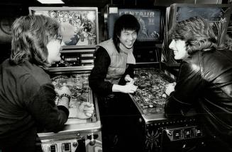 Street talk: Social worker Stan Chong, centre, chats with Stewart, left, and Stephen at video parior in Scarborough. Chong's job is to cruise the city's youth hangouts in search of the unemployed who have either been forgotten by the system or have simply opted out. Once he locates them, he advises them on how to go about finding a job.