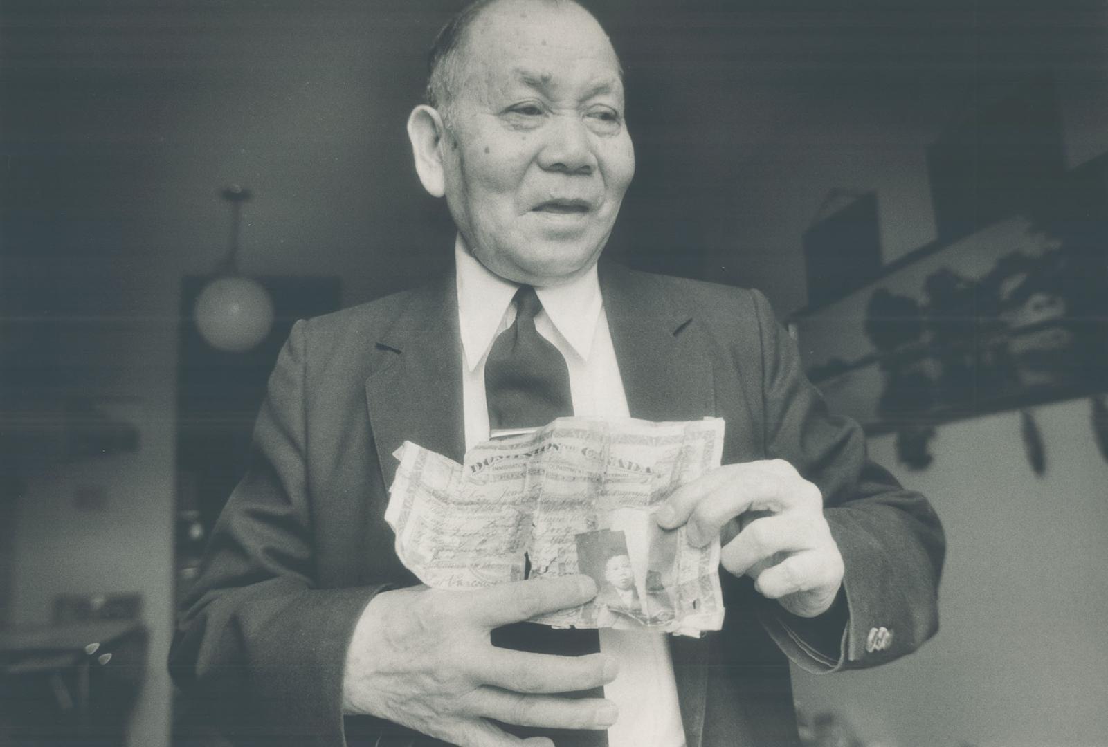 John Chow, who came to Canada in 1922, holds his torn head tax certificate. Some 81,000 Chinese immigrants paid the levy.