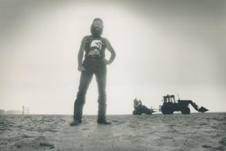 Sand man: Mark Culligan, one of Toronto's two full-time beachcombers, uses the front-end loader and attachment behind him to sift for gunk.