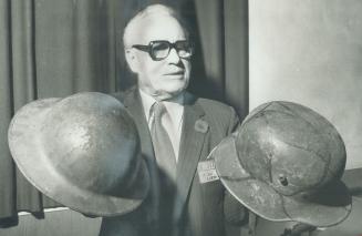 Vivid memories are stirred by these World War I steel helmets, on the left a Canadian tin hat and on the right a German sniper's helmet. L. W. Currell, a businessman and retired lieutenant-colonel, displayed the helmets at a talk on the battle of Vimy Ridge in which Canadian troops distinguished themselves. Currell, a 19-year-old private at the time, told of the battle in Erindale Untied Church last night.