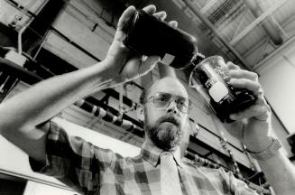 Black gold: Herb Campbell, a research engineer at the Canada Centre for inland Waters, pours oil produced from sewage sludge into a beaker. The novel concept could turn the sludge into a valuable resource rather than an expensively disposed - of waste. Petro Sun international Inc. is getting set to take the process out of the lab into the marketplace.