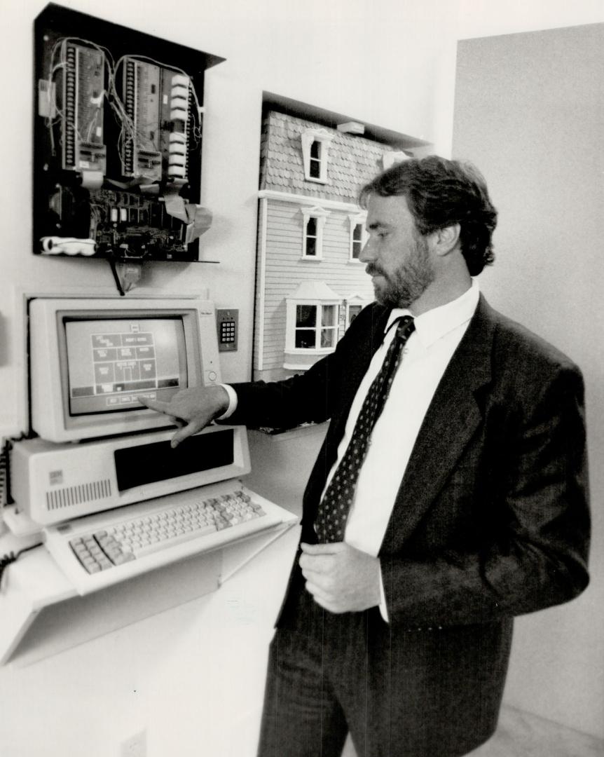 Nerve centre: Tom Christoff programs the Brian (on wall above computer screen), which controls household operations like furnace, smoke alarms and lawn sprinklers. Doll house behind Christoff is fitted with lights and mini-TV to show off Brian's powers.