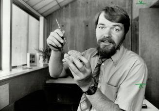 Brainy handful: Prof. Doug Chute shows animal brain used in course research.