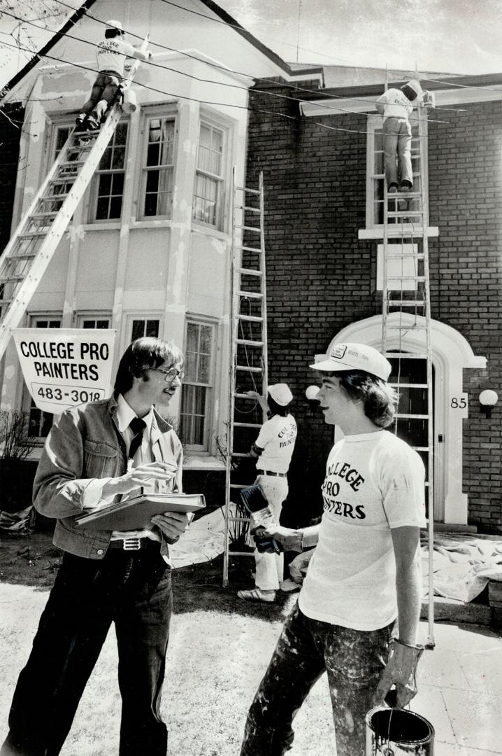 Greig Clark (left) explains work order to Graham Appleton, one of the students working for Clark's College Pro Painters company. He expects to sign $1 million in contracts between now and September and employ up to 250 student painters.