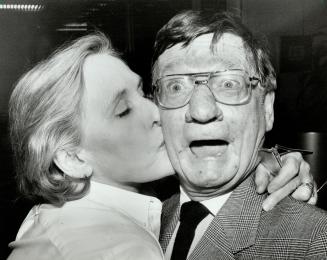 Glenn Cochrane, recipient of a City of Toronto citation honoring his many years on CFTO-TV, receives a kiss from Councillor Kay Gardner, reminiscent of the way he used to end his reports.