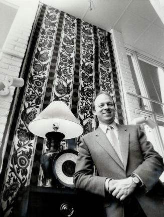 Frank Codd, presidet of Interior Designers of Ontario, shows use of dramatic wall fabric to add warmth, individualize room.