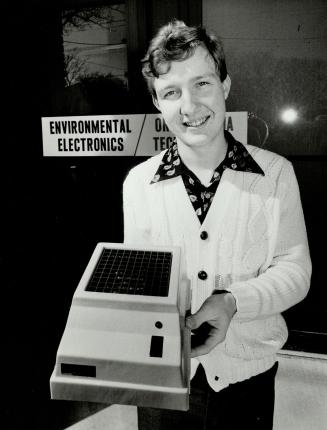 Young scientist: Twenty-year-old Wayne Conrad of Whiby holds air cleaner ionizer he designed and manufactures at his own plant.