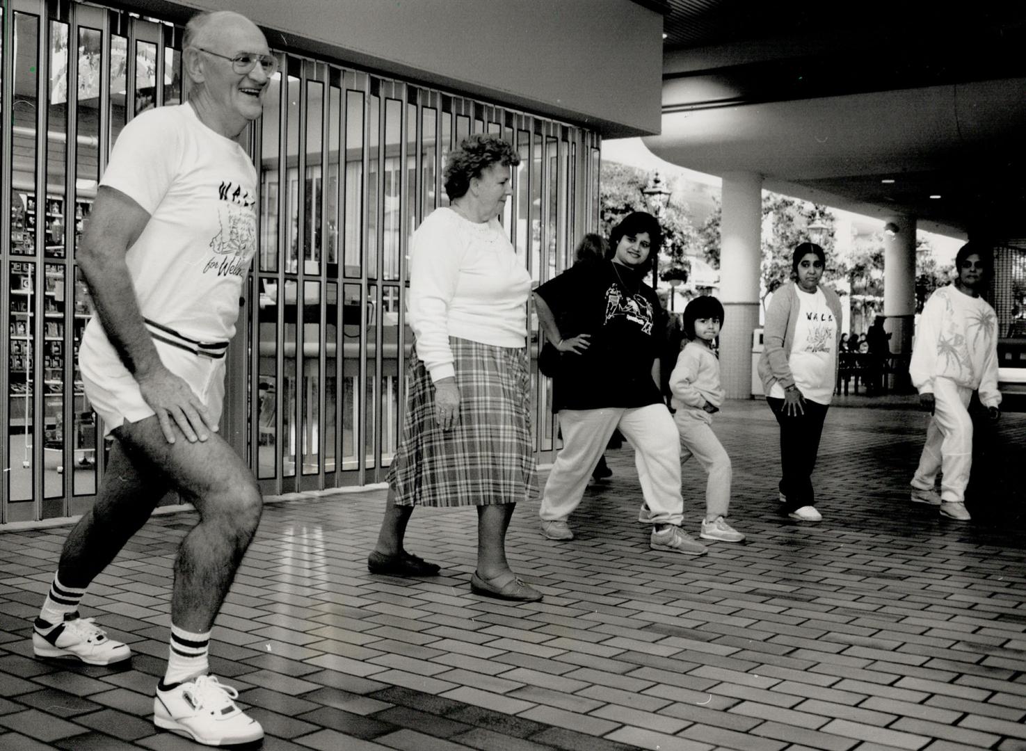 Walk for wellness. Ken Cox leads a group in stretching exercises before the walkers begin their circuit of the Hillcrest Mall in Vaughan.