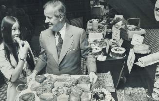 Maple Leaf Mills Ltd. president and chief executive R. G. Dale, offers some of company's products to shareholder Gina Wigle, 17, of Etobicoke, at firm's annual meeting yesterday at Harbour Castle Hotel, only a short distance from company's head office at 417 Queen's Quay West. The baked goodies were tangible evidence of recent takeover of Pillsbury Canada Ltd. which was acquired by Maple Leaf Mills last month.