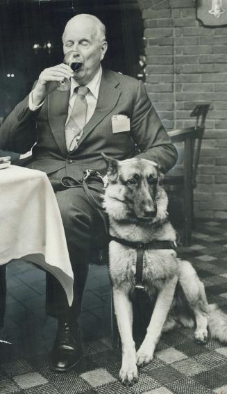 Moment of Truth comes for house wine at restaurant in Royal York Hotel as Baron Roy Andries de Groot tastes it. Verdict: Not great, but good value. Famed blind gourmet, accompanied by seeing eye dog, Atena, is here for gastronomic festival. He rates city one of two or three greatest eating places.