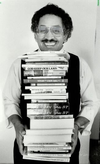 Load of learning: Desmond De Gastro gets a stack of books ready for shipment to the Caribbean. De Gastro buys and collects books in Canada and sends them to religious schools.