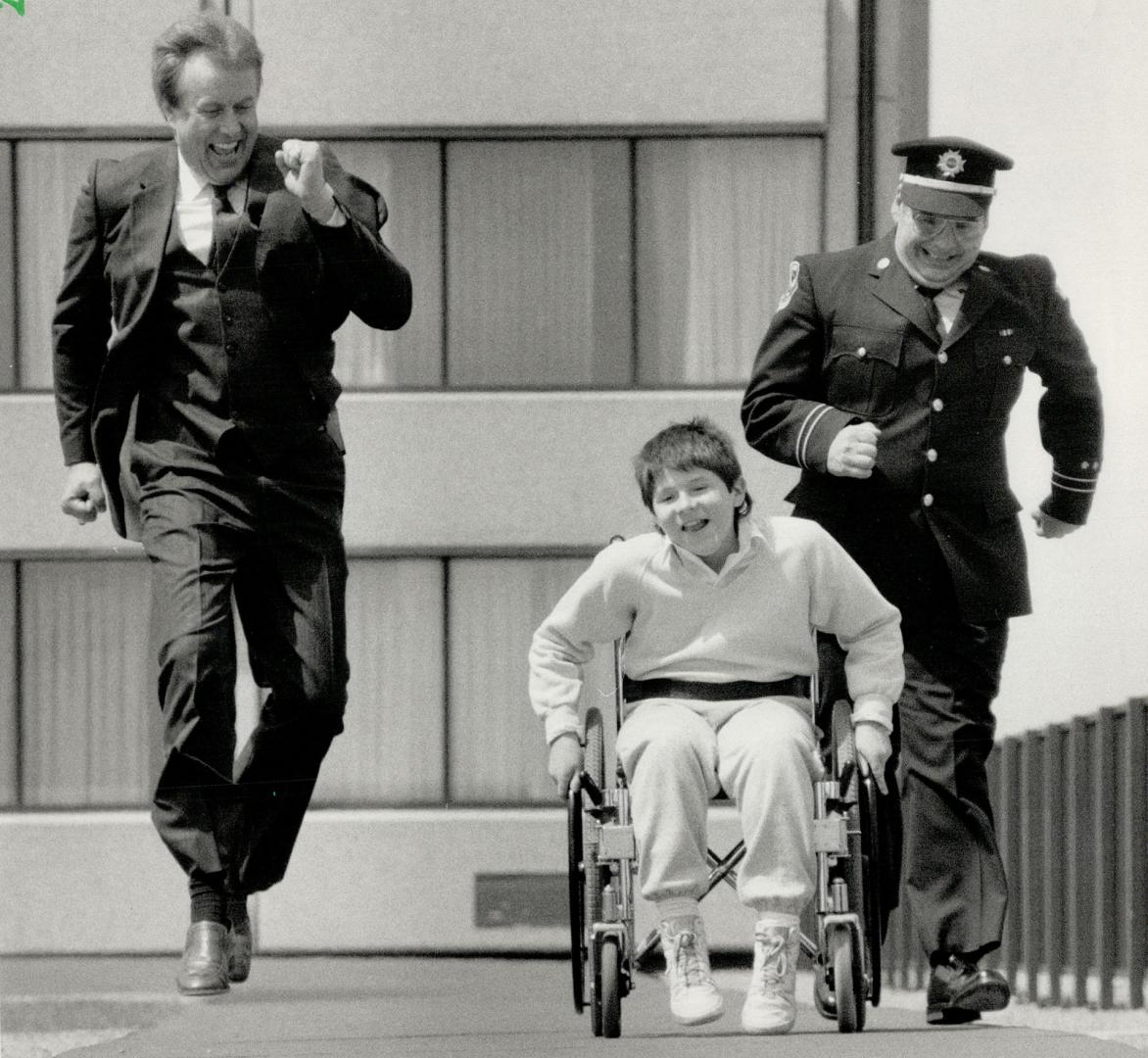 Telethon team: Stephen Desi, 11, assistant to Ontario team in the Jerry Lewis Muscular Dystrophy Telethon, races chairmen Mike Darow, left, and Brampton fire Captain John Prankard, right.