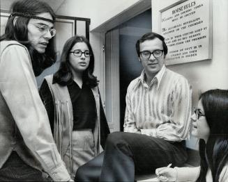 At the Toronto Indian Centre, James Dumont, 26, left, chats with Daphne Johnston, Joseph Hare, director of the centre, and Marie Sylvester Dumont, an Ojibway from Shawanaga near Parry Sound, earned a divinity degree but took a post at the centre on Beverley St. instead of becoming a United Church minister because he considers the Christian church has tried to suppress the Indians' native culture.