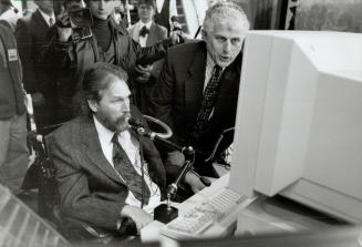 To an accessible workplace, Bill Etherington, president and CEO of IBM Canada, helps Larry Broden work a voice-activated drafting station at this week's official opening of Access Place in Toronto's College Park.