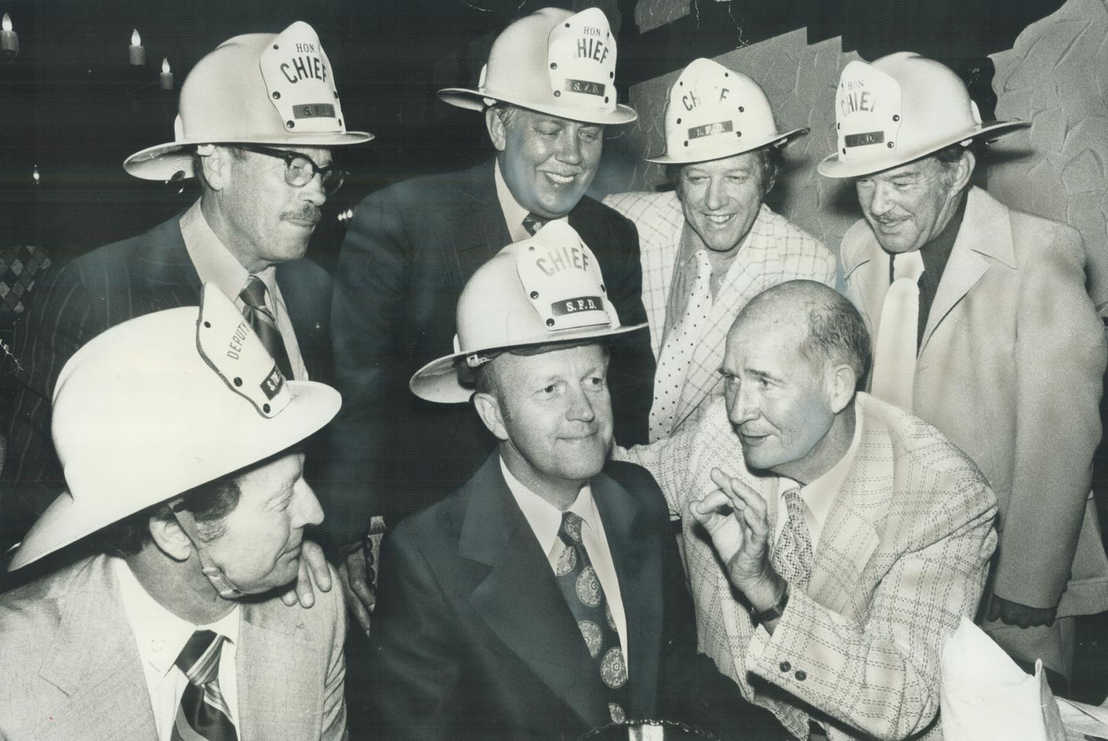 The helmet fits-- he'll wear it. Eight honorary fire chiefs of Scarborough were hosts at one of several borough parties honoring Fire Chief Dave Forgie, 63, who is retiring after 35 years with department, 8 of those years as chief. Forgie (right, front gi