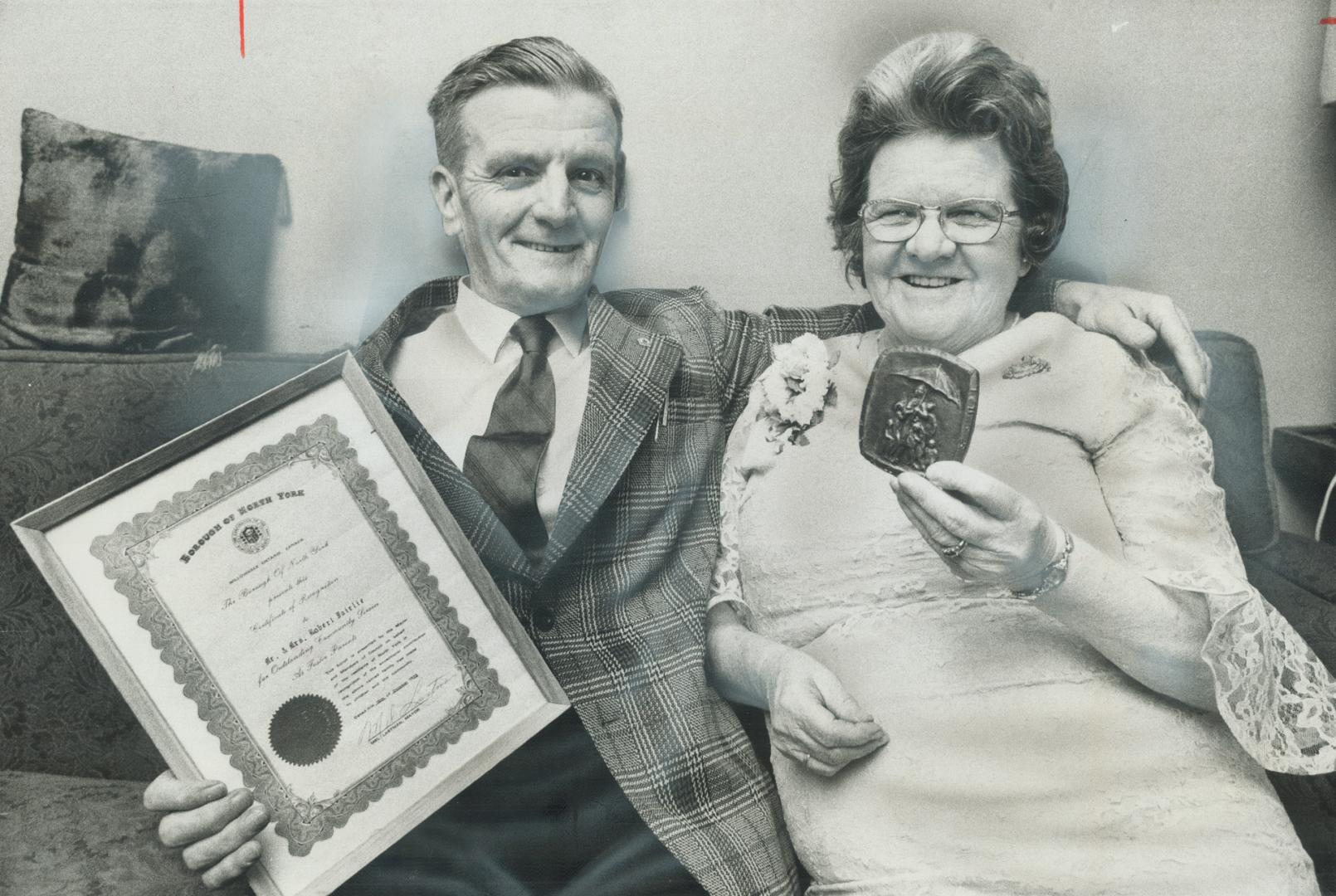 Foster Parents to more than 60 children over the past 25 years, Robert and Ada Fairlie of North York hold the medallion and scroll presented to them last night at the annual meeting of the Metro Toronto Children's Aid Society.