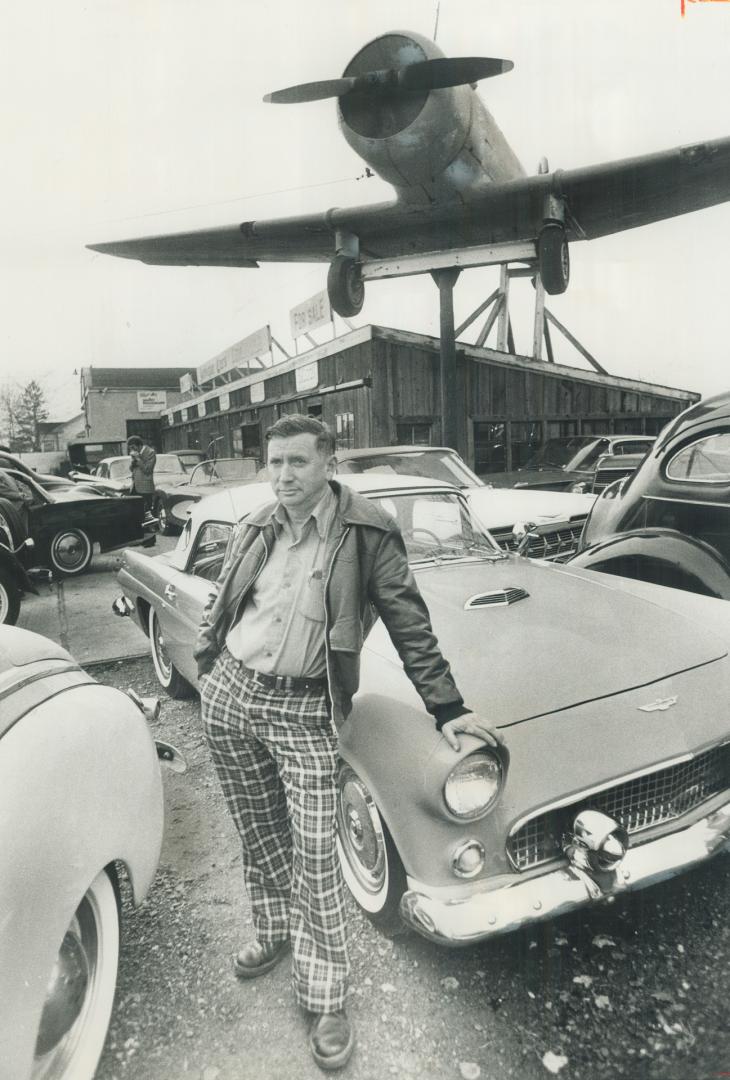 Old cars come out like new. Restoring antique cars is the hobby and the business of Ron Fawcett of Whitby leading on a 1956 Thunderbird under the Harvard trainer mounted on the roof. Fawcett has restored cars for museums in Ottawa. Oshawa and Niagara Fall