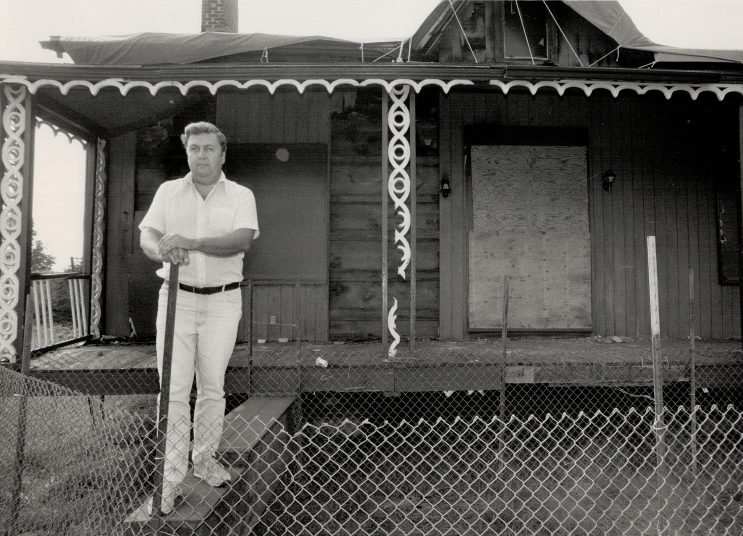 Victim of arson: David Falconer, administrator of the North York Historical Board, stands in front of the burned out historic John Duncan House, fenced in to keep out vandals. A four-month battle to save the old wooden house, badly damaged in a June fire