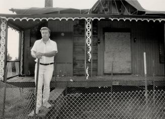 Victim of arson: David Falconer, administrator of the North York Historical Board, stands in front of the burned out historic John Duncan House, fenced in to keep out vandals. A four-month battle to save the old wooden house, badly damaged in a June fire