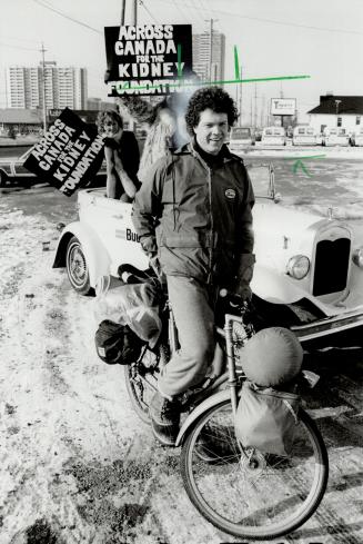 Defying icy roads, bitter iwnds and the longest highway in the world since he left Vancouver Jan. 7, adventurer Mike Flynn is cycling across Canada because it is there. The tall, 32-year-old cyclist from Niagara Falls is also zooming across the country -