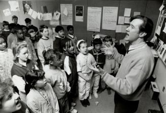 Larry Folk, a Metro music teacher reassigned to a regular class, leads a lunch-hour choir practice at St. Thomas More school.