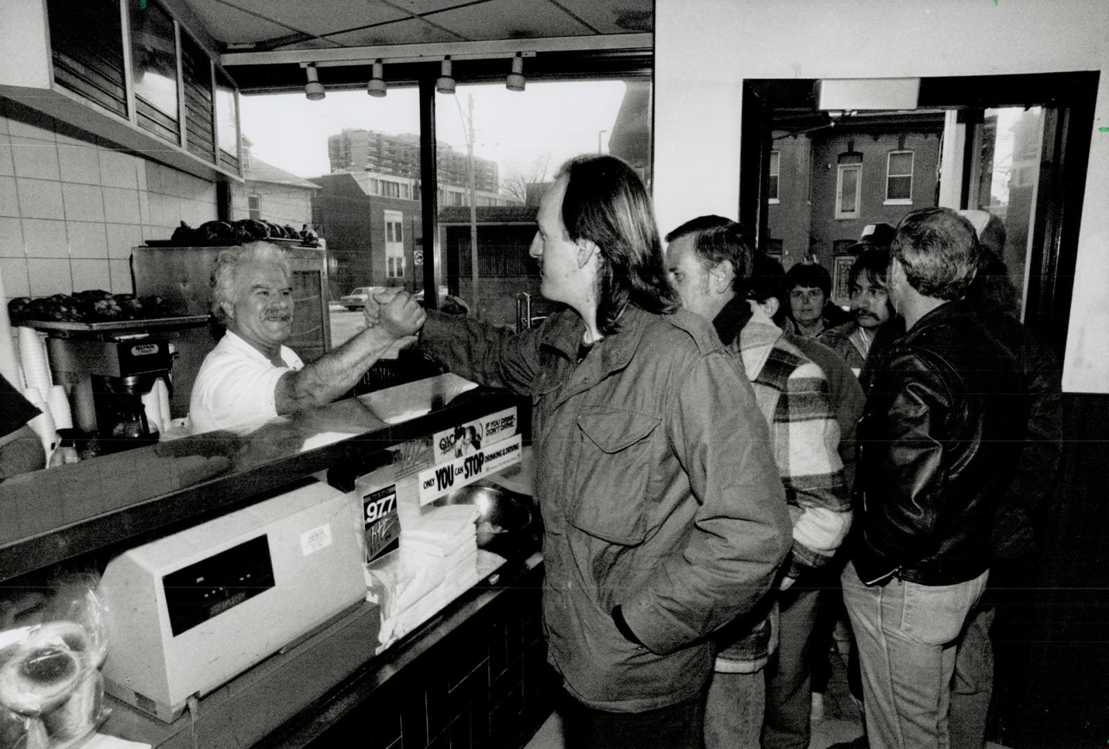 Happy host: George Garavellos, left, greets some of those who dropped into his Dundas St