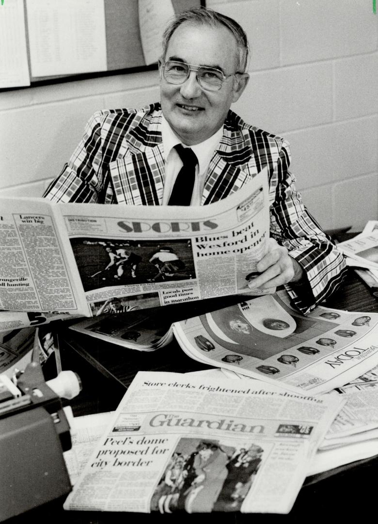 That's Scoop: Brampton Guardian Sports Editor Ken 'Scoop' Giles sports a maroon and white checked sports jacket, with matching tie and slacks, as he catches up on the day's news