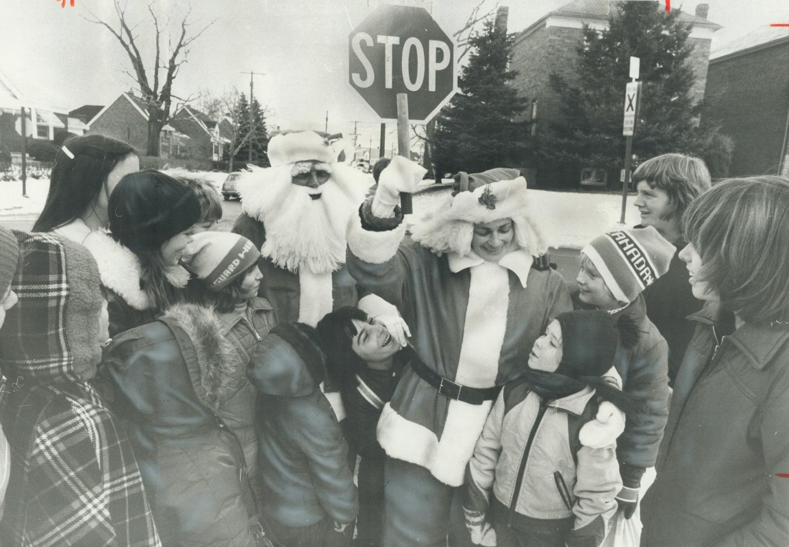 Real traffic stoppers in Scarborough yesterday were Marjorie and Harry Gordaneer in their Santa Claus costumes. Mrs. Gordancer, who has been a crossing guard for 20 years and is president of the Metro school crossing guards' organization, has been handing out candy canes to youngsters at her crossing on Clonmore Dr. Husband Harry, who's an area supervisor with the borough's board of education, has been playing Santa at a number of schools this week.