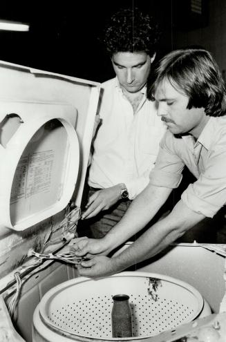 Extended service: Errol Gordon, left, whose company offers a five-appliance protection plan for $99 for one year, examines a washing machine with serviceman Paul Murchison