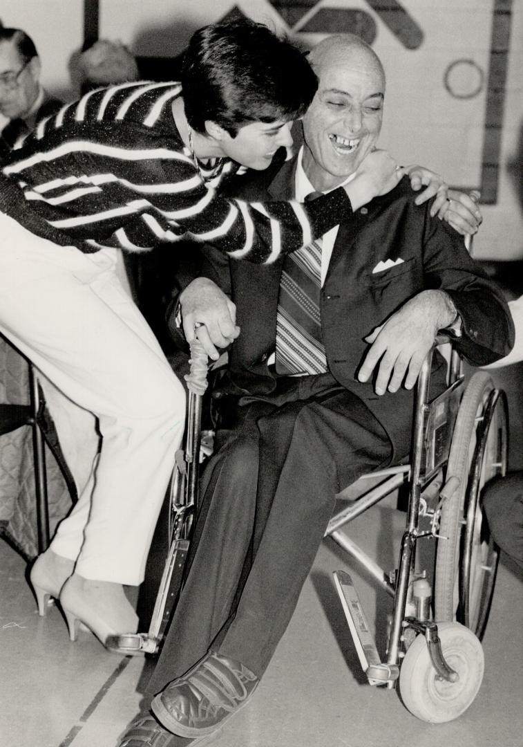 Super salesman: Cerebral palsy victim Harry Halpern receives a hug from friend Laura Toniutti after he was honored by the Canadian Cancer Society for his fund-raising efforts