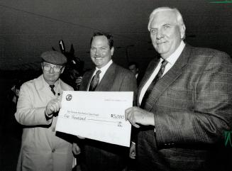 Going in style: After Precious Bunny's final lap, owner Peter Heffering, right, and son David present The Star's Jim Proudfoot with a cheque for Santa Claus Fund