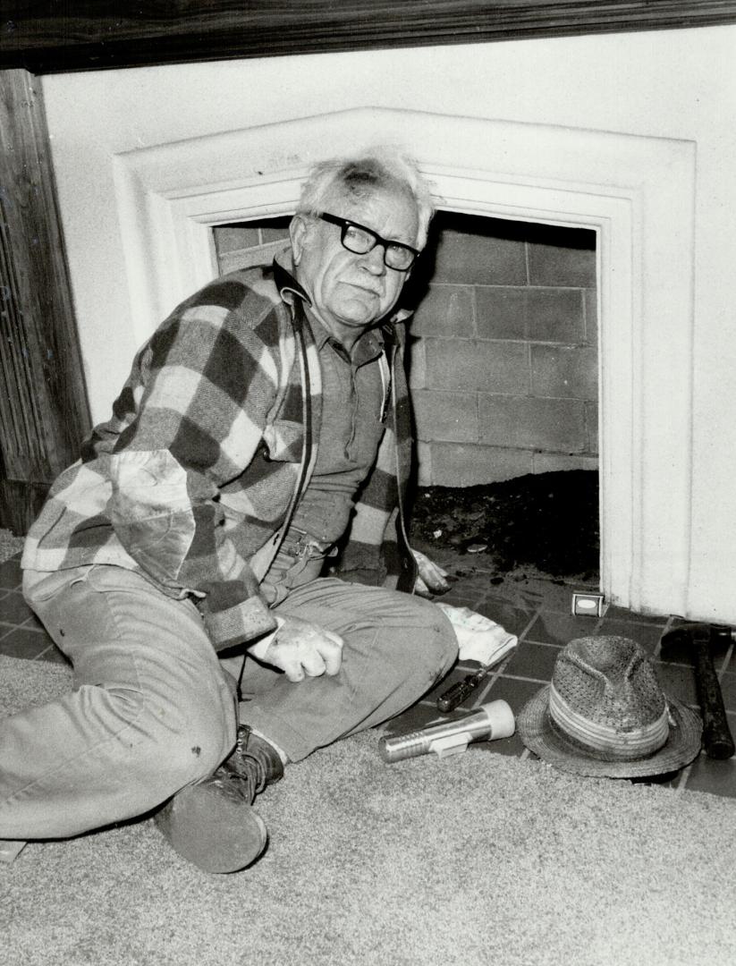 Trapper at work: Les Hill sometimes climbs onto the roof to attack raccoons from above or sticks his head in the fireplace to get them from below and either approach usually draws an interested party (left)