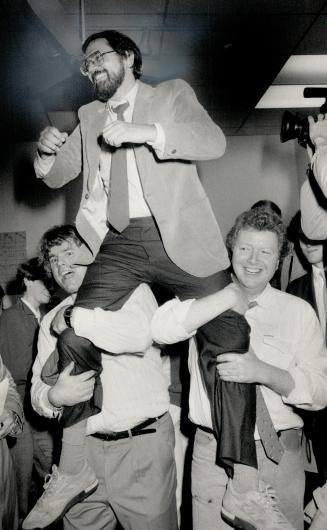 Riding high: Roger Hollander is hoisted on the shoulders of John Piner, left, and Bruce Cox after winning the by-election to fill the vacant Ward 7 seat on city council last night