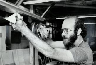 Wood work instructor Tom Hurley. Waxing a table he's just completed