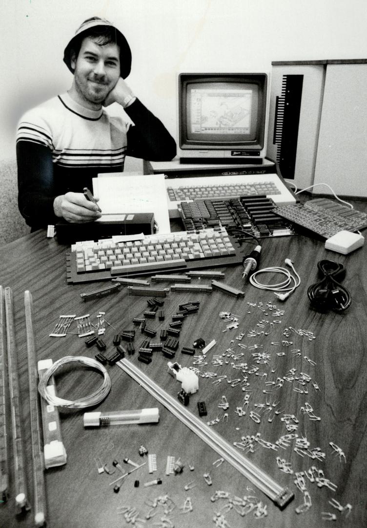 Where do you start? Rory Jan, 24, who has helped people build microcomputers from kits for 2 years at the U of T, sits by assembled and unassembled parts of an Apple clone