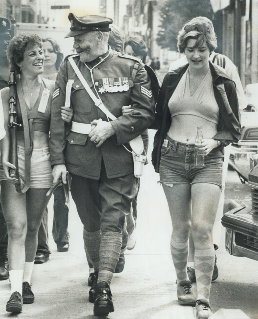 Eyes... right! Not lacking for admirers, Fred Lewis, 55, is all spit and polish in World War I cavalry sergeant's uniform as he marches on Saturday in the Royal Canadian Legion's walkathon to raise $25,000 for the Metro Toronto Legion Lodge. Lewis, who retired in 1971 after 33 years in the army, acquired the uniform during his travels and wore it to publicize Legion's 50th anniversary. Claire (left) and Lori McMahon were comrades-in-arms.