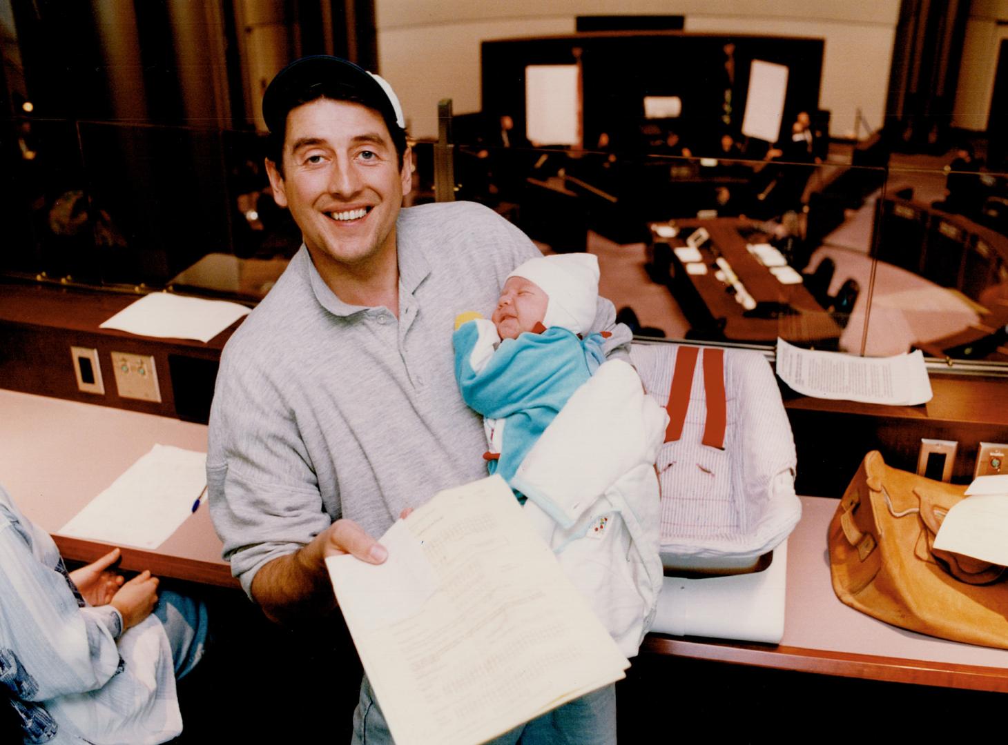 Third time lucky? Andrew Kosc has 5-week-old son Joseph along for moral support today as he gathers the documents at Metro Hall council chambers for his third bid at a sidewalk vending space