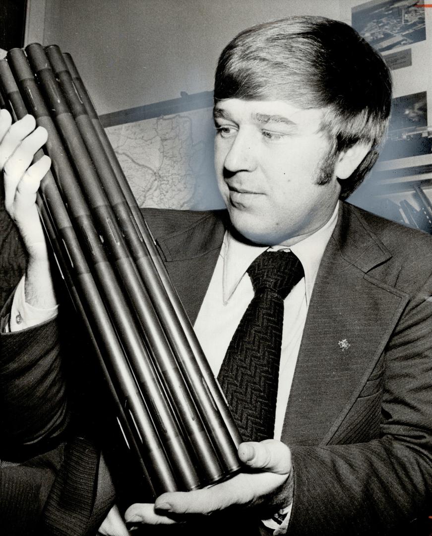 Roland Krause of Atomic Energy of Canada, in Mississuga, holds a model of a uranium bundle that cost $700 and, when placed in a nuclear reactor, produces as much energy as 100,000 gallons of oil