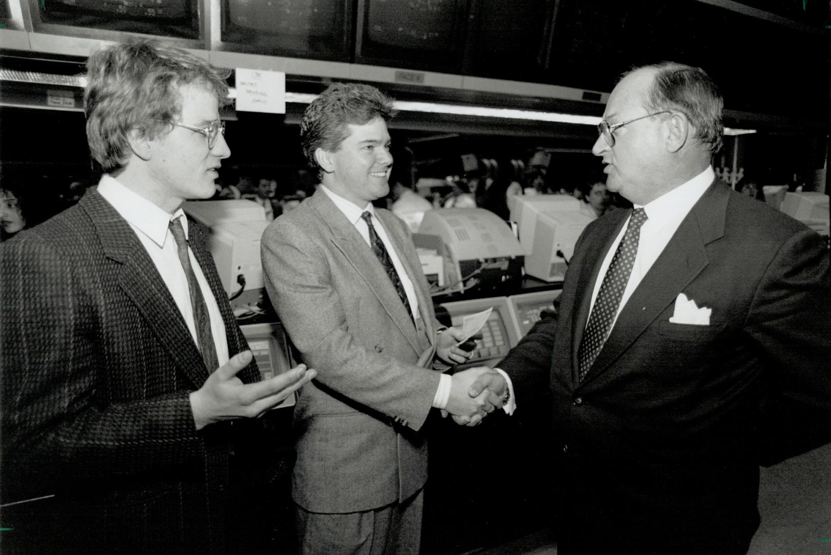 Helping needy: Midland Walwyn's Rod Syms, right, presents his firm's $86,000 cheque to Daily Bread Food Bank chairman Larry Lancefield, with Gerald Kennedy, Daily Bread executive-director, at the Toronto Stock Exchange