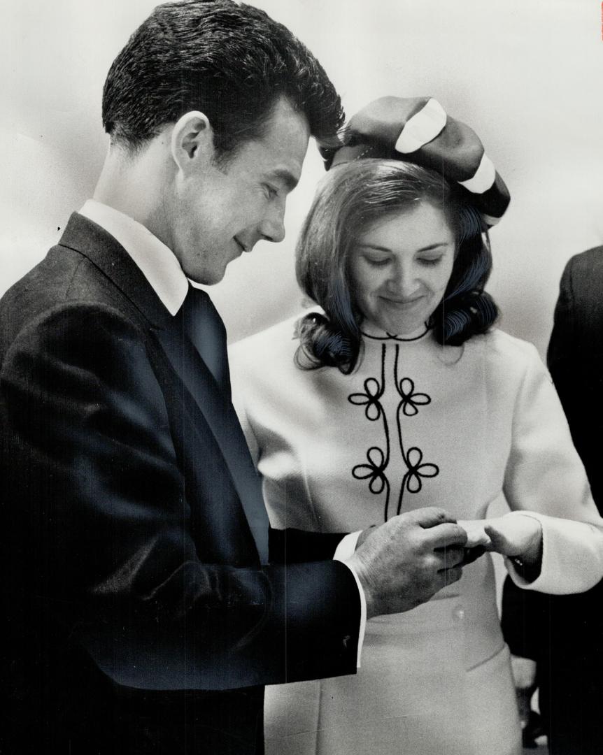 Starting a new life, David Lumsden, only survivor of a fire in which his wife and six children died, adjusts wedding ring on the finger of his bride, Ann Silver, 21, after a five-minute marriage ceremony at city hall yesterday