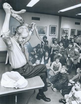 Boa construction squirms above his head as former Etobicoke science teacher Bruce McBride shows youngsters at Eatonville Library on Saturday how to handle reptiles