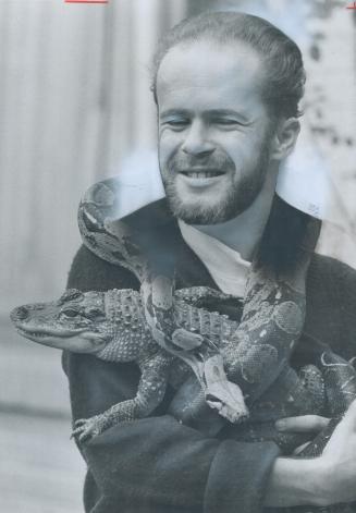 Logist Bruce McBride holds Maxine, his 5-foot constrictor, and fred, his alligator