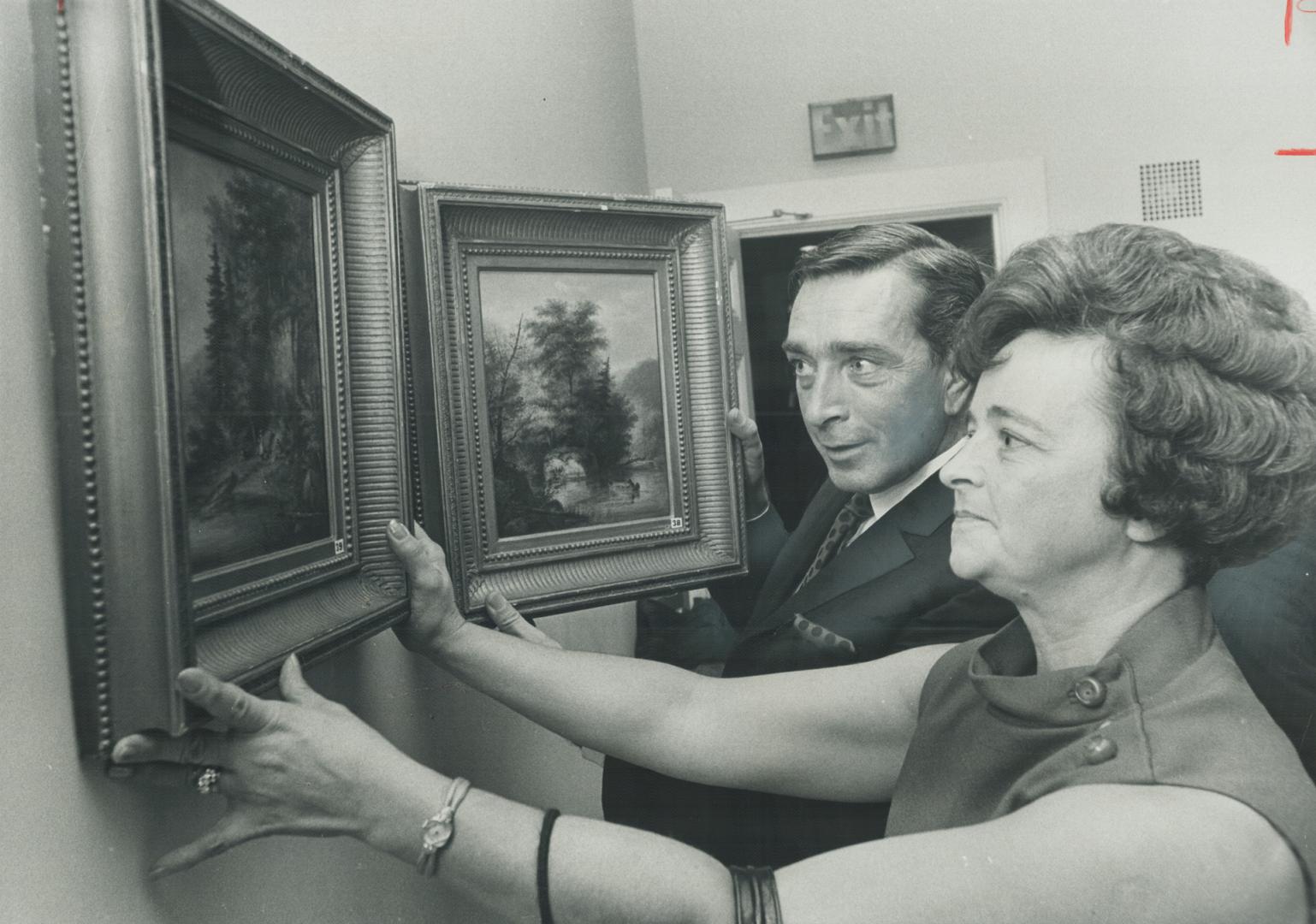 Mr. and Mrs. Gordon H. McCullough of Etobicoke admire the two Cornelius Kriefhoff paintings that cost them $17,000 at the Collectors' Choice auction at the St. Lawrence Hall last night. The auction was estimted to have raised close to $50,000 for the National Ballet School scholarship fund. The bidding was fast and furious as Metro's 400 went all out for the paintings and antiques.