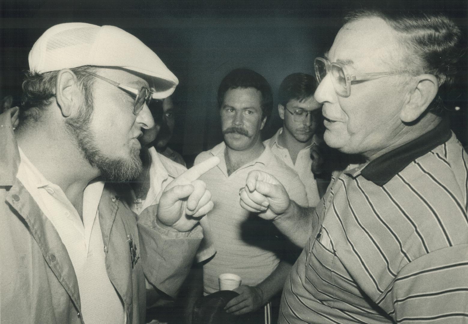 Angry clash: Union member Tom North, left, argues with Fred Malashewski, general chairman of CN Rail's Brotherhood of Railway Carmen, after a rowdy union meeting last night at a Keele St